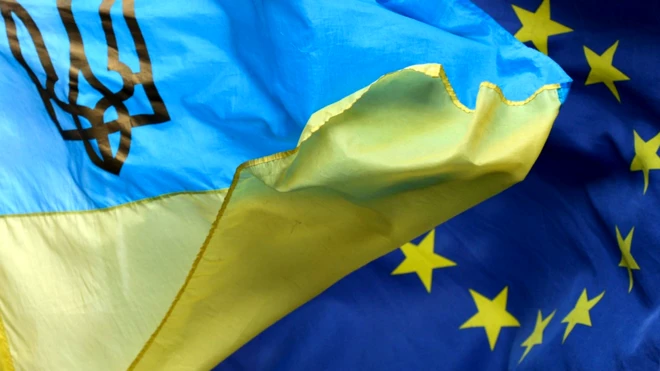 Le drapeau de l'Ukraine avec le symbole du trident du pays à côté du drapeau de l'UE