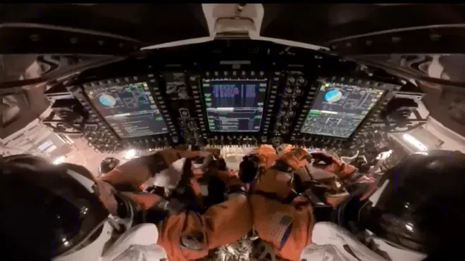 En el interior de la cápsula Orion, los astronautas Reid Wiseman (izq.), comandante, y Victor Glover (der.), piloto, preparan la nave espacial Orion para el reingreso a la Tierra.