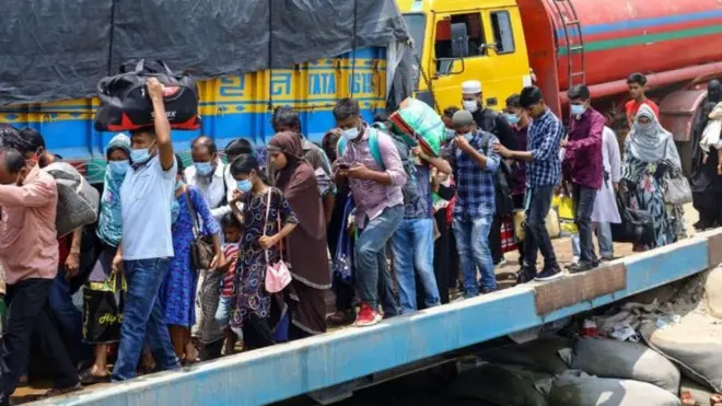 কিছু মানুষ ব্যাগ নিয়ে সারিবদ্ধভাবে ফেরিতে উঠছেন। তাদের পেছনে একটি ট্রাক ও একটি লরি