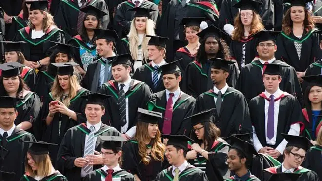 นักศึกษาถ่ายรูปหมู่ในพิธีจบการศึกษา