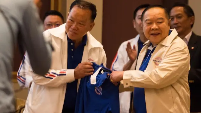 พล.อ.ประวิตร สวมเสื้อที่มีโลโก้ใหม่ พปชร. ก่อนยืนยันกับผู้สื่อข่าวว่า พปชร. "กลมเกลียวกัน ๆ"