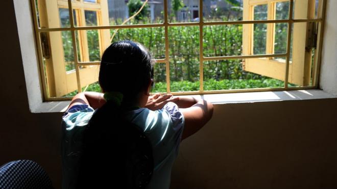 looking out from a window at a centre for trafficked women in the northern city of Lao Ca