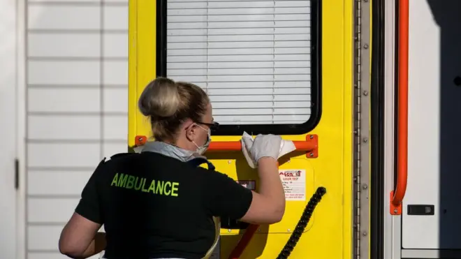 Trabajadora de salud limpiando una ambulancia