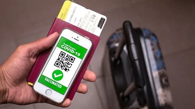 มือคนถือโทรศัพท์และพาสปอร์ต