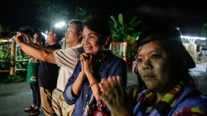 Las personas congregadas afuera de la cueva celebraron la salida de los primeros niños.