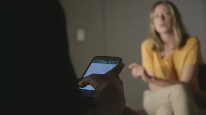 대화방 운영자가 BBC 취재진(노란옷)과 인터뷰를 하며 스마트폰 대화방을 확인하고 있다