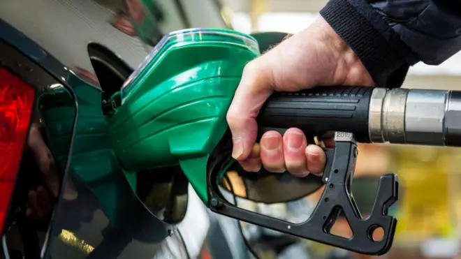 ለመኪና ነዳጅ የሚሞላ ግለሰብ 