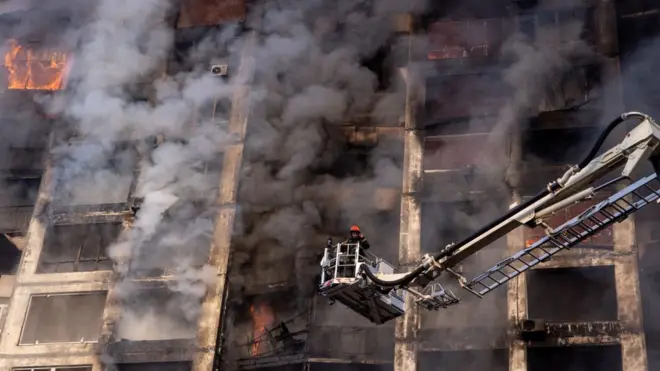 Firefighters work to extinguish a blaze at a residential apartment building that was hit by a Russian attack in the early hours of the morning in the Sviatoshynskyi District, 15 March 2022