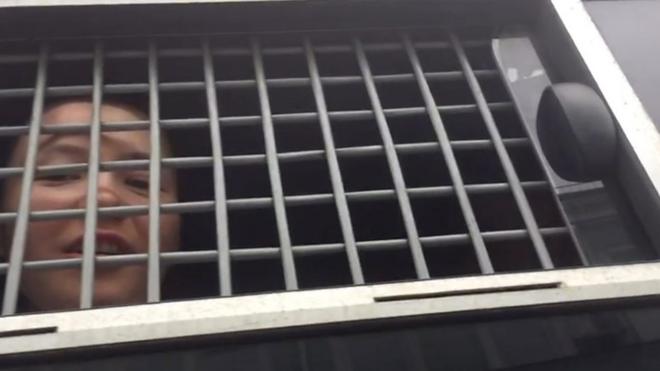 Задержанная на акции в Москве в окне автозака.