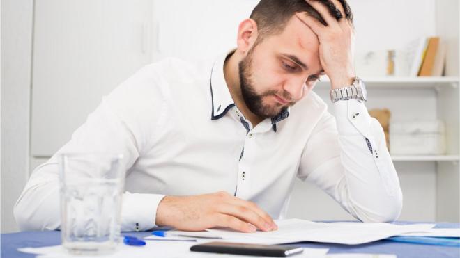 Homem preocupado com dívidas