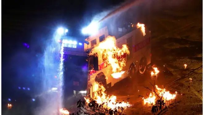 示威者放火焚烧警方的车辆。