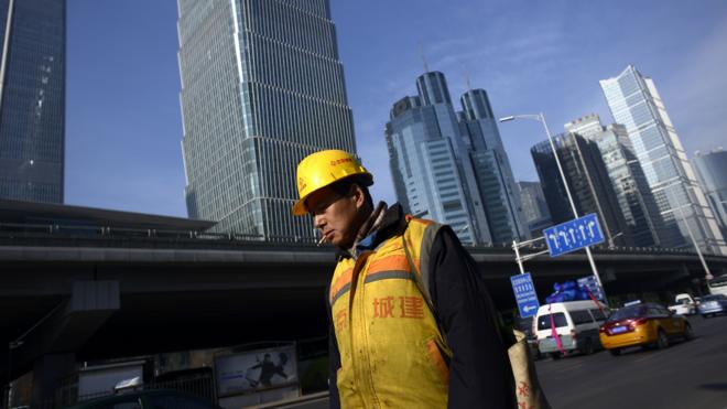 北京街头某建筑工地外的一名工人（16/12/2016）