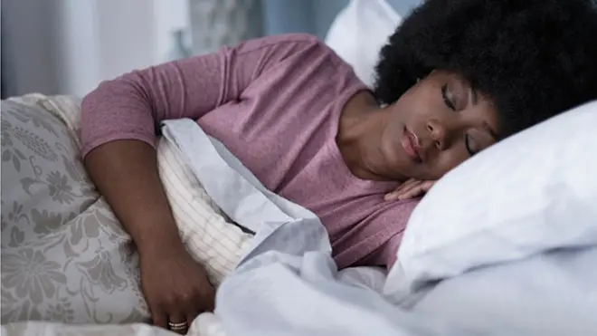 Femme qui dort dans son lit