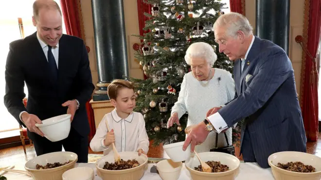 Queen Elizabeth II, the Prince of Wales, the Duke of Cambridge and Prince George preparing special Christmas puddings in the Music Room at Buckingham Palace, London, as part of the launch of The Royal British Legion"s Together at Christmas initiative