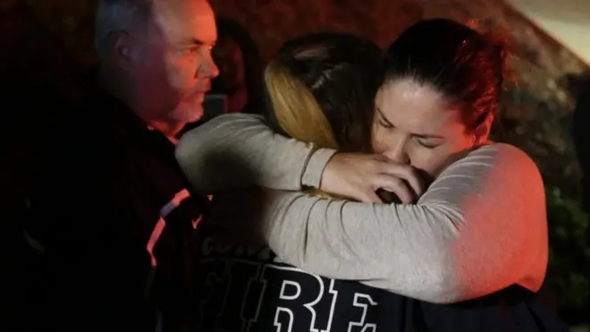 Two women hug outside the shooting