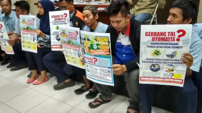 Para pegawai tol memprotes kewajiban transaksi nontunai di gerbang tol.