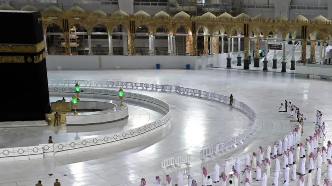 Worshippers dey perform Isha prayer as dem dey keep distance between dem next to di Kaaba for Mecca's Grand Mosque