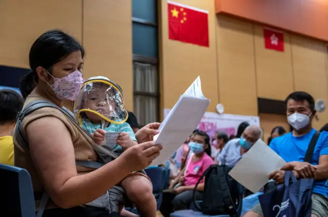 2022年8月11日,在一所疫苗接種中心內,一名母親抱著一名嬰兒。