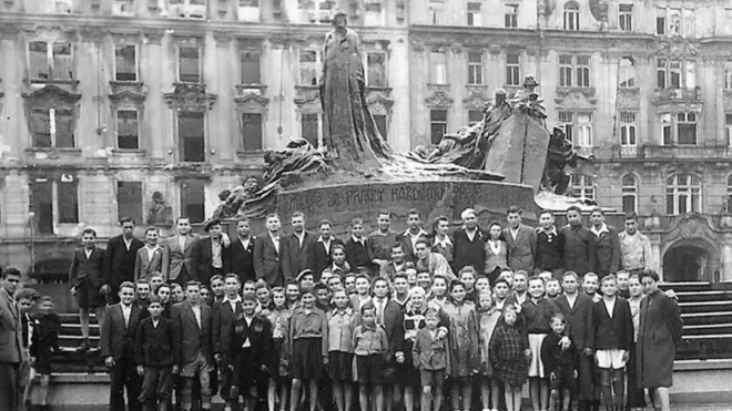 Korban selamat dan keluarga mereka berfoto berdasarkan foto tahun 1945 ini.