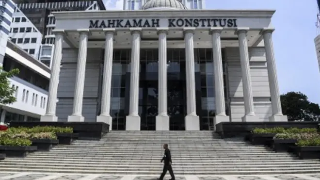 Petugas keamanan melintas di depan Gedung Mahkamah Konstitusi. Sesuai dengan UU Nomor 7 Tahun 2017 tentang Pemilihan Umum, MK membuka layanan penerimaan permohonan perselisihan hasil pemilihan umum 3x24 jam sejak penetapan perolehan suara oleh KPU.