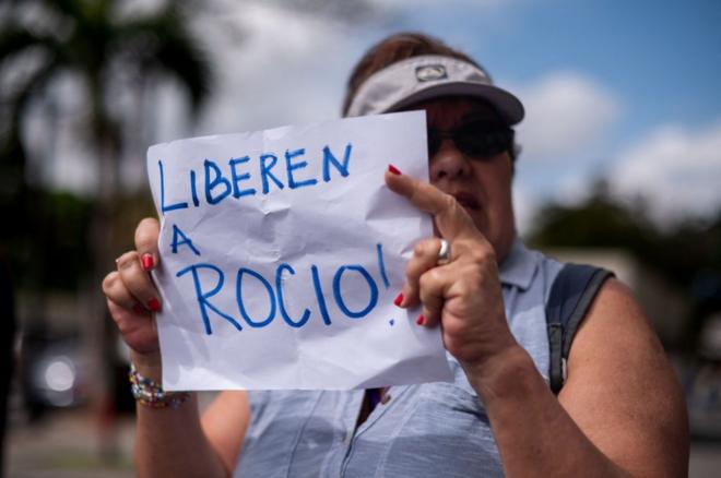 Mulher segura cartaz que diz: 'Liberem Rocio'