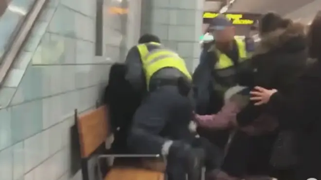 The video showed the woman being overpowered by two guards as her daughter looked on
