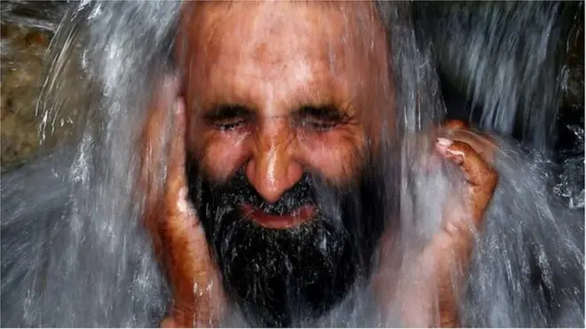 পানিতে ভিজছেন একজন