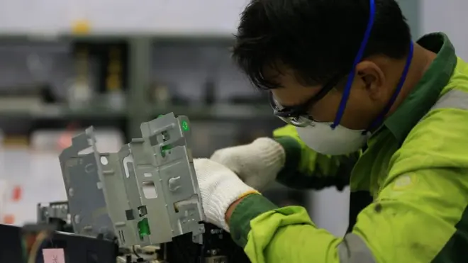 Seorang staf PPLI tengah membongkar dan mempreteli komputer usang.