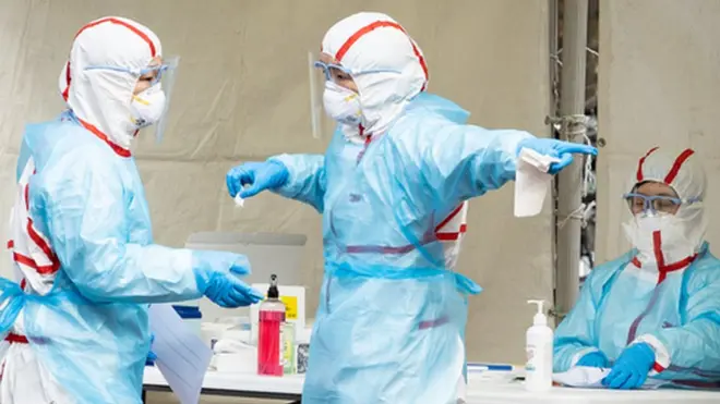 신종 코로나바이러스 감염증(코로나19) 확진자가 1,000명을 돌파한 26일 서울 강동구 명성교회 앞에 마련된 임시 선별진료소에서 관계자들이 분주히 움직이고 있다