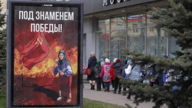 Сітілайт з зображенням української бабусі з червоним прапором і написом "Під прапором перемоги" У Санк-Петербурзі