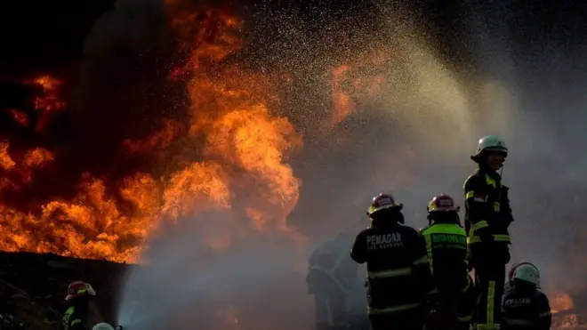 Petugas berusaha memadamkan api saat kebakaran pipa minyak milik PT Pertamina di Melong, Cimahi, Jawa Barat, Selasa (22/10)