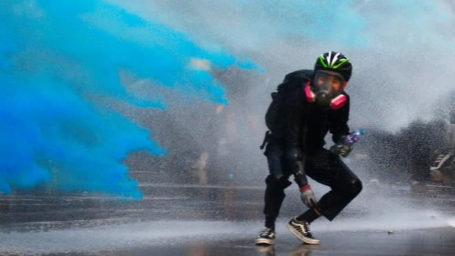 An anti-government protester is sprayed with blue-coloured water in Hong Kong - 15 September 2019