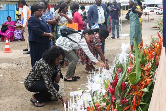 Des parents et des amis déposent des bougies et des fleurs pour les personnes disparues lors du naufrage d'un ferry, au port de Libreville, le 13 mars 2023.