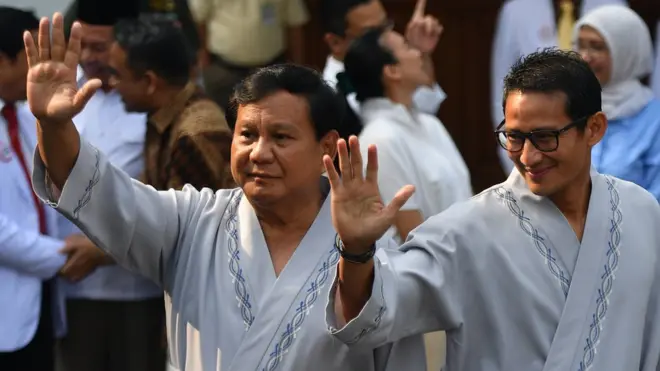 Bakal calon presiden dan wakil presiden Pilpres 2019 Prabowo Subianto (kiri) dan Sandiaga Uno (kanan) melambaikan tangan usai pemeriksaan awal tes kesehatan di RSPAD, Jakarta, Senin (13/8).