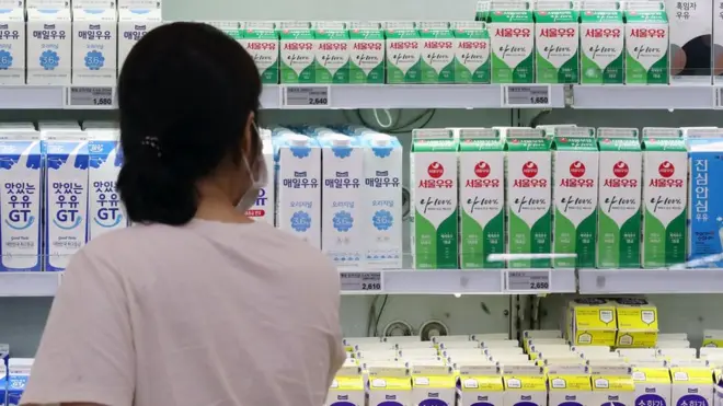 마트 우유 진열대 앞에 서있는 여자