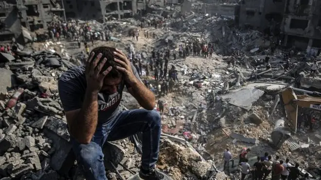 A man, sitting on debris, clutches his head as Palestinians conduct a search and rescue operation after the second bombardment of the Israeli army in the last 24 hours at Jabalia refugee camp in Gaza City, on 1 November 2023
