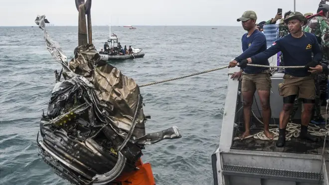 Sejumlah penyelam TNI AL menarik puing turbin pesawat Sriwijaya Air SJ 182 ke atas KRI Rigel-933 di perairan Kepulauan Seribu, Jakarta, Senin (11/01).