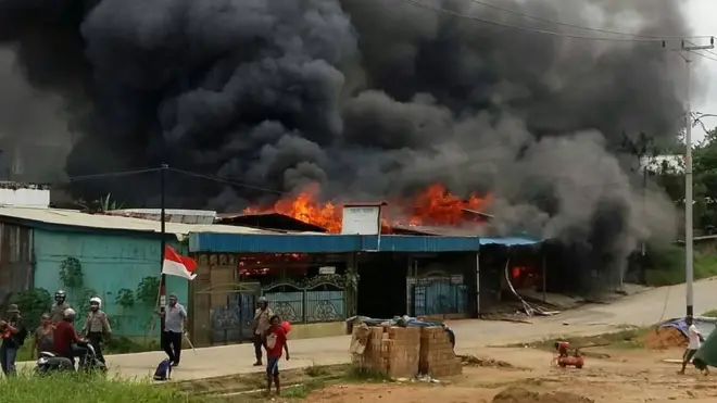 A building, set on fire by rioting demonstrators, is seen in Sorong