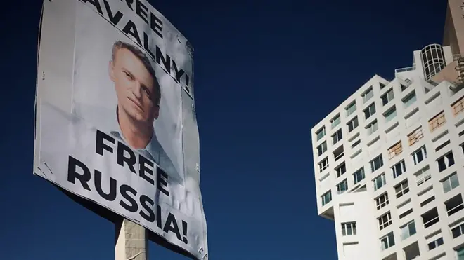 Плакат с Навальным на фоне здания.