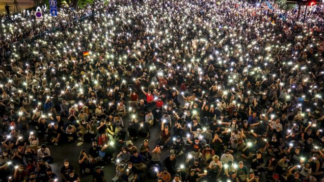 Pro-democracy protesters hold up their mobile phones during rally against the state of emergency at Ratchaprasong shopping district in Bangkok, Thailand, 15 October 2020.