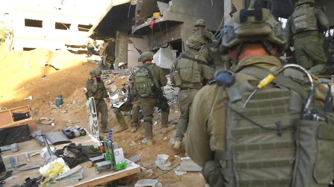 Israeli forces walk through ruins of buildings