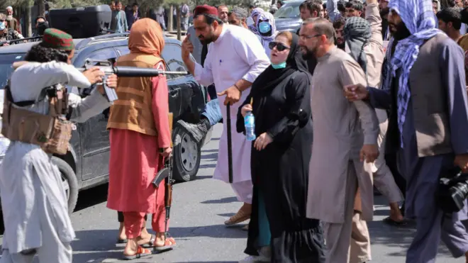 یک جنگجوی طالبان اسلحه خود را به سمت یک زن معترض در کابل نشانه می رود