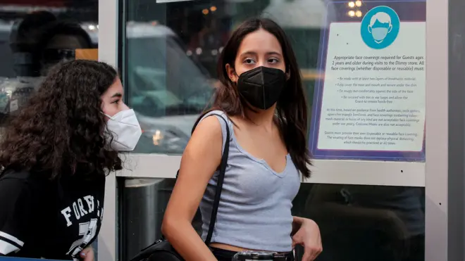 纽约市街头两位少女戴着口罩走过一家商店（27/7/2021）