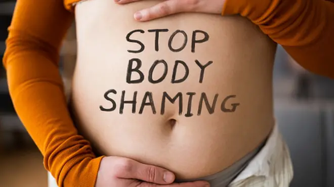 A woman with Stop Body Shaming written on her belly