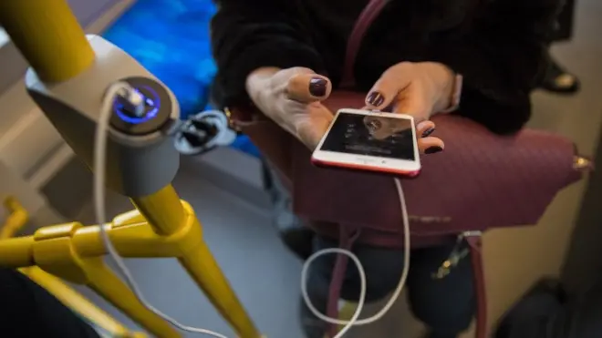 Дівчина заряджає мобільний телефон в салоні трамвая у Києві, 12 січня 2018 р.