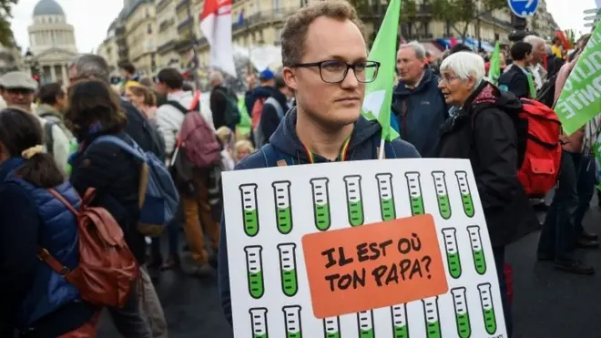 A demonstrator holds a sign reading "Where is your daddy?"