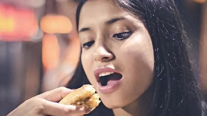 చిరుతిండి తింటున్న యువతి