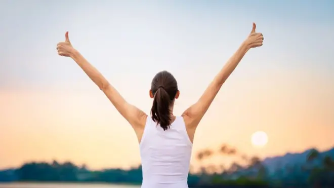 Mujer alzando los brazos