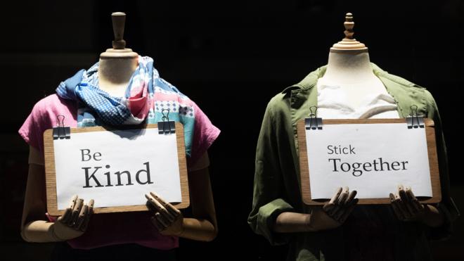 Shop mannequins with signs - be kind and stick together