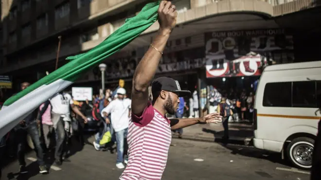 No be today dis palava start. One man hold Nigeria flag for Johannesburg for 2015 as Nigerians protest attacks against dia people for South Africa